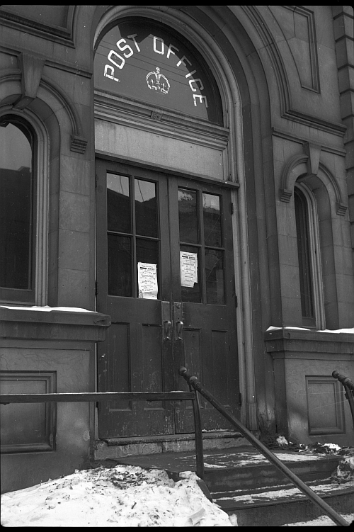 Post Office doors with sign above.