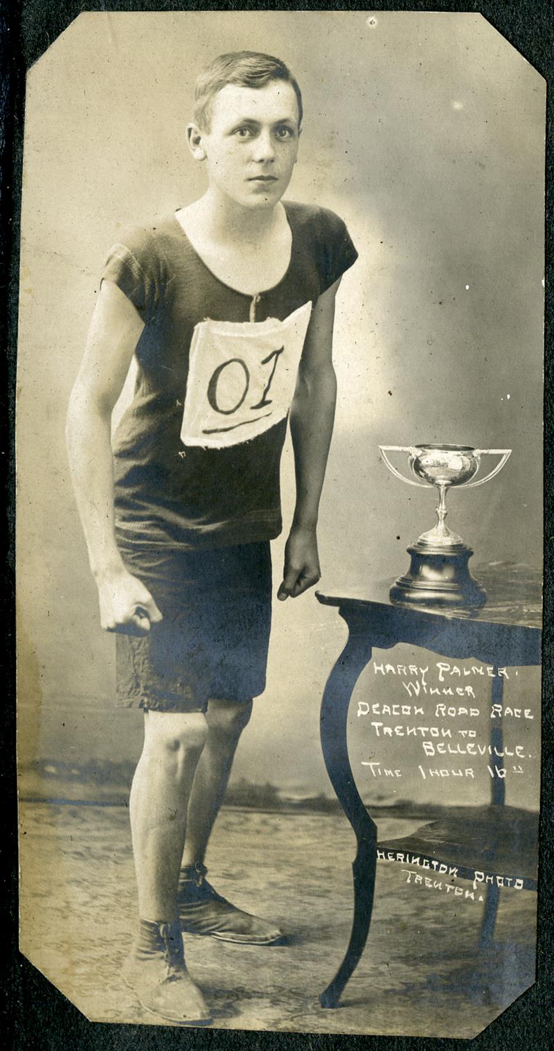 A young man in athletic clothing with a trophy.