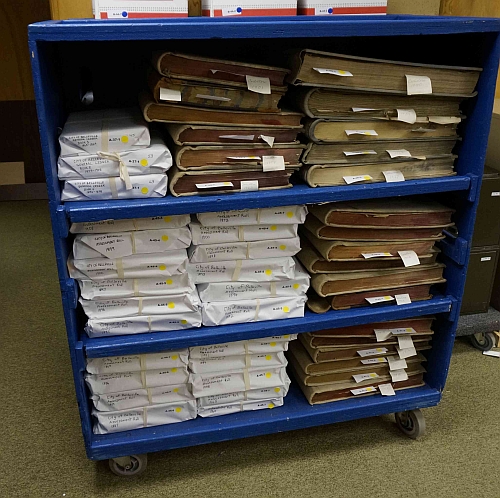 Wooden cart stacked with volumes.