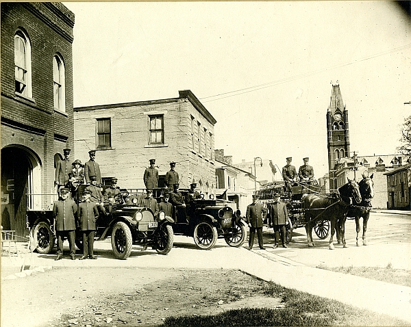 Two new motorized fire trucks, with Harry and team mate hooked to the ladder wagon, at No. 1 Fire Hall, lower Front St., Belleville, circa 1921.