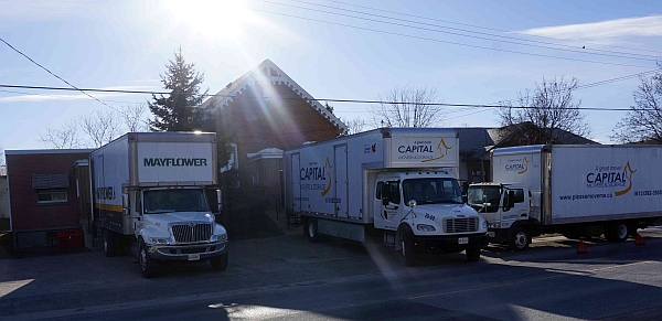 Moving trucks outside former archives building.