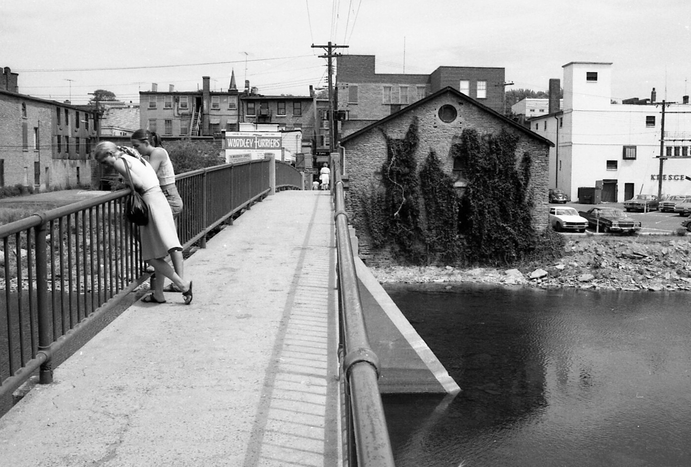 Two women on concrete footbridge.