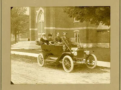 Four people in a vintage car.