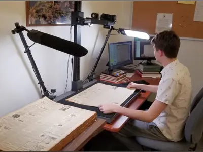 Zac Miller photographing a newspaper.