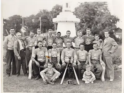 Baseball team standing in front of a concrete fountain.