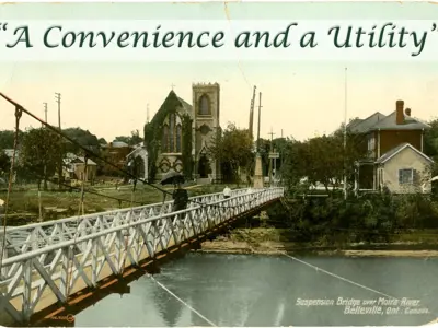 Postcard of footbridge with words "A Convenience and a Utility".