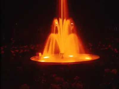 Photograph of an illuminated fountain at night.