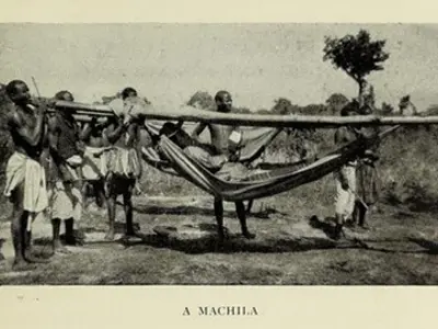 People carrying a person in a machila hammock.