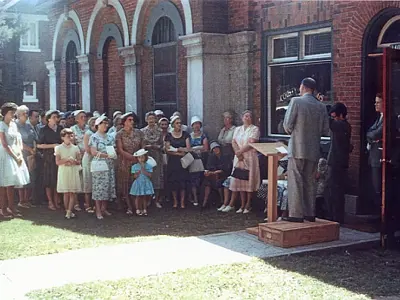 Crowd of people outside a redbrick building.