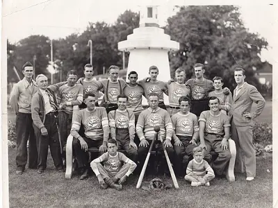 Baseball team standing in front of a concrete fountain.