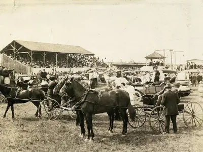 Horse-drawn vehicles at a fairground.