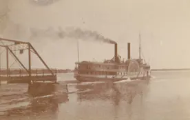 Steamship passing through the swing section of a bridge.